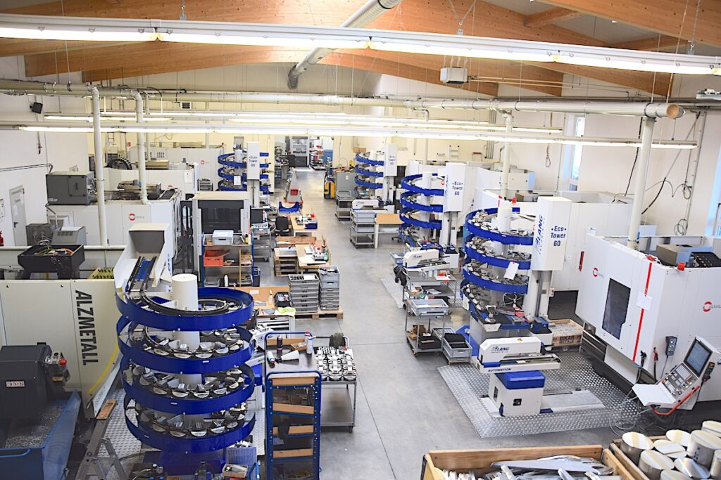 In der erweiterten Produktionshalle von HFH Präzisionsmechanik GmbH stehen mehrere CNC-Maschinen und blaue Werkzeugtürme für die Fertigung bereit.