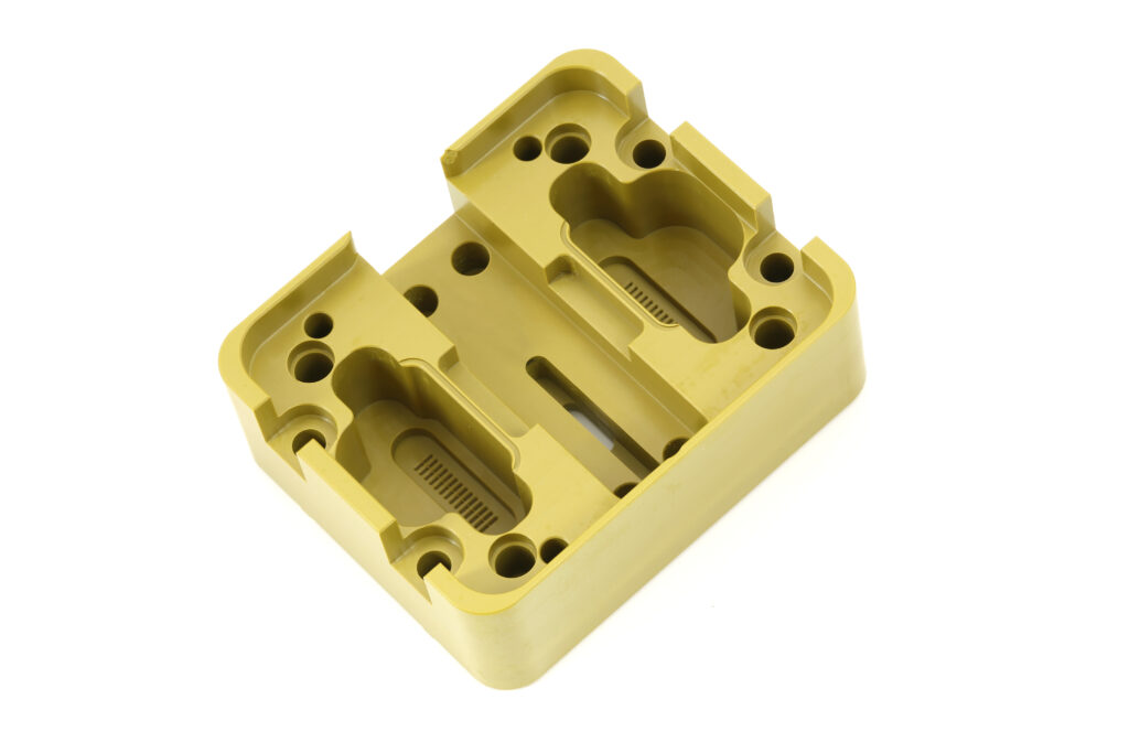 Goldfarben eloxiertes CNC-gefrästes Aluminiumbauteil mit präzisen Bohrungen, Ausfräsungen und Konturen von HFH Präzisionsmechanik in Niederbayern.