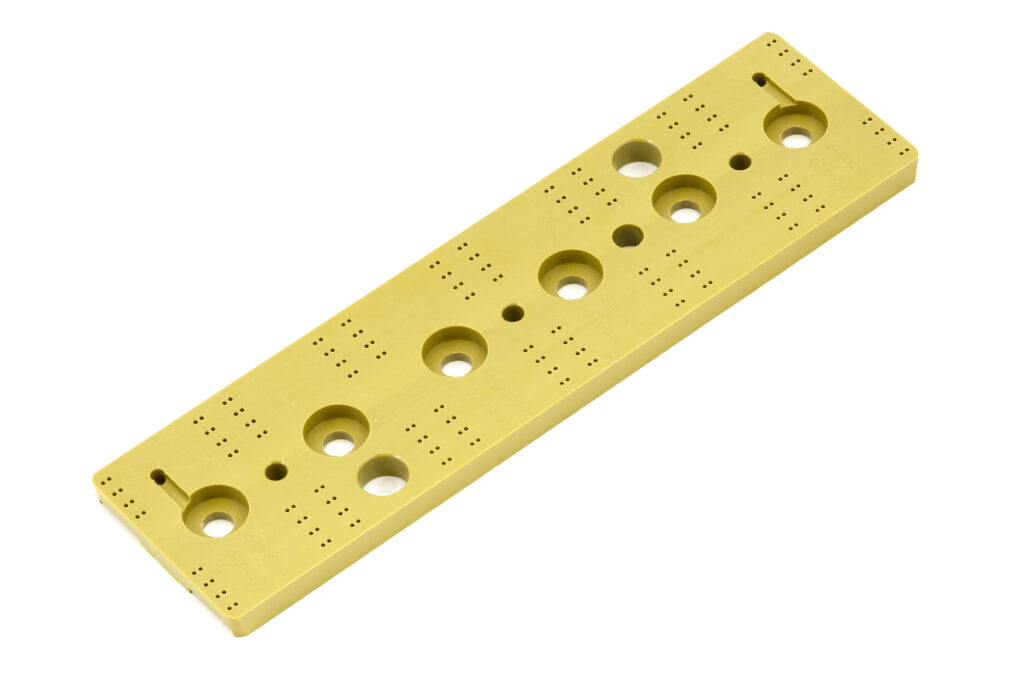 Ein eloxiertes CNC-gefrästes Aluminiumbauteil in Gelb zeigt präzise Bohrungen, Senkungen und feine Lochmuster für komplexe Fertigungsteile.