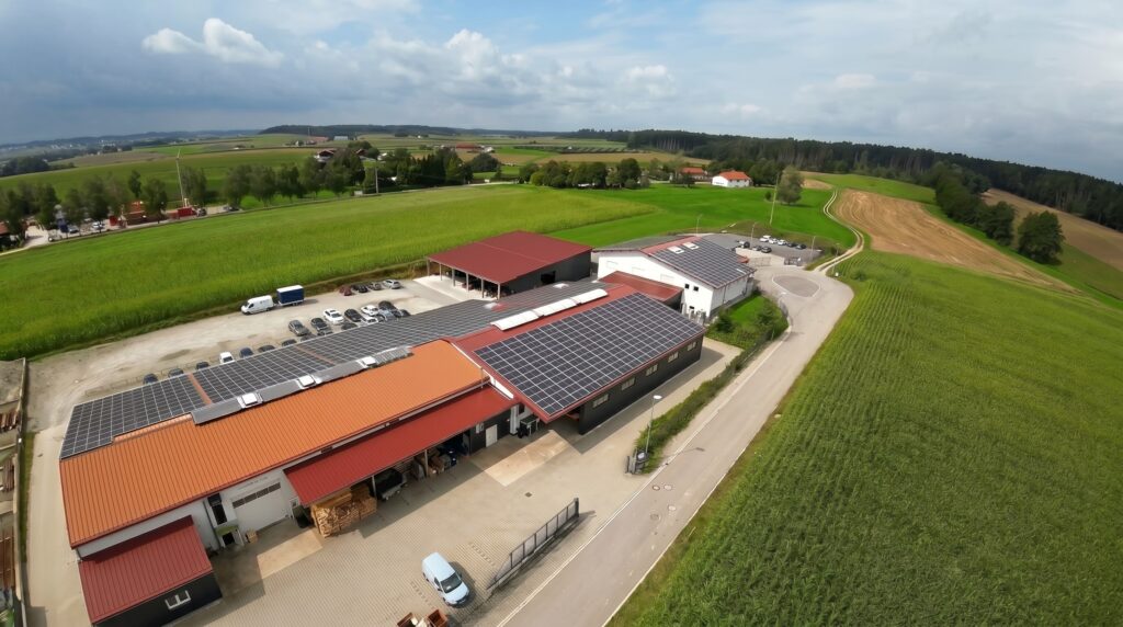 Aus der Luft zeigt sich das Firmengelände von HFH Präzisionsmechanik GmbH mit mehreren Hallen, Solardächern und umgebenden Feldern in Niederbayern.